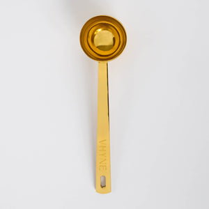 The Perfect Measure Spoon from Vhyne - a gold measuring spoon with VHYNE branding on a white background