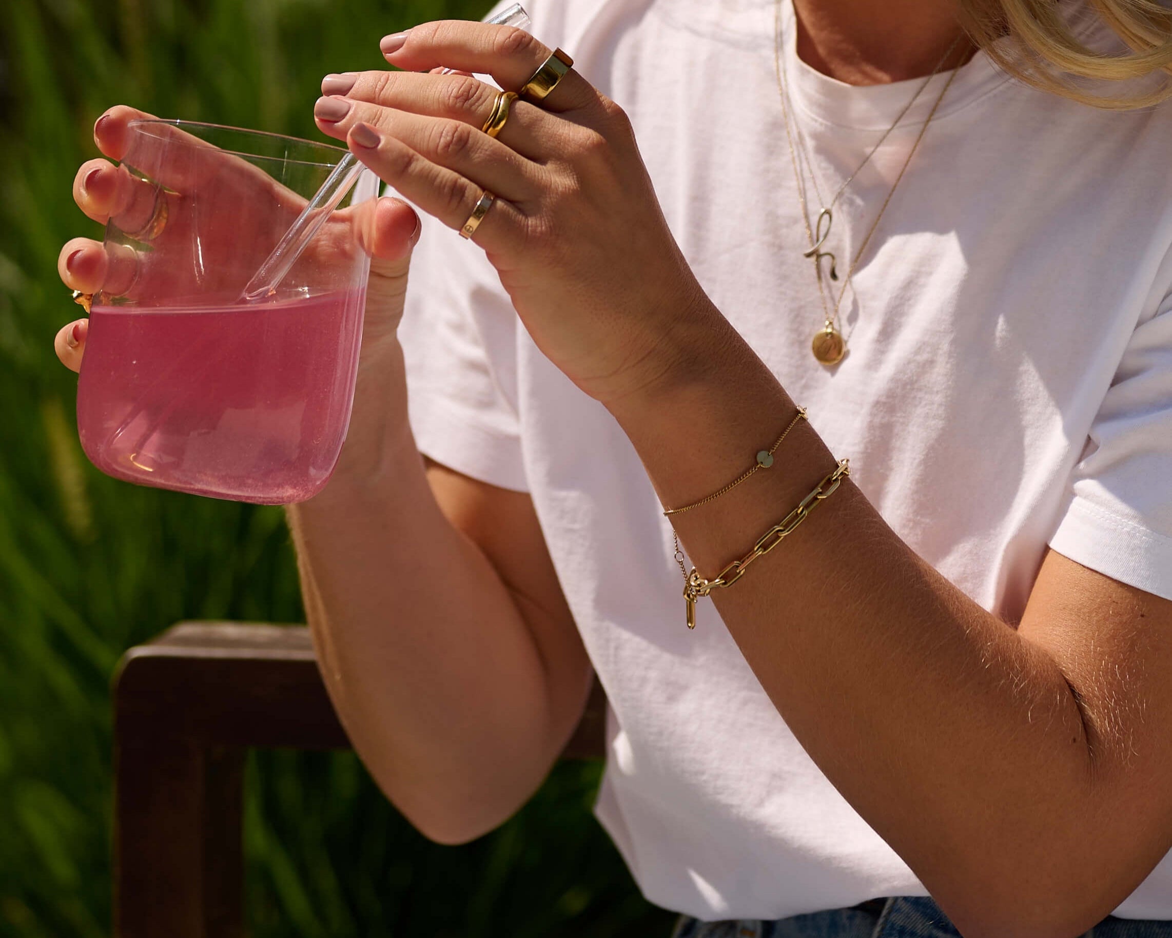 Person holding a glass of VitaResiliance with a glass straw outdoors